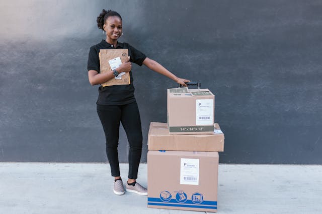 woman standing beside several boxes