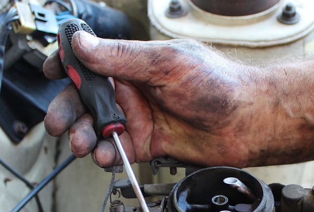 mechanic’s hand with a screwdriver